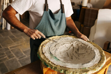 Crop artisan with clay tools in workshop