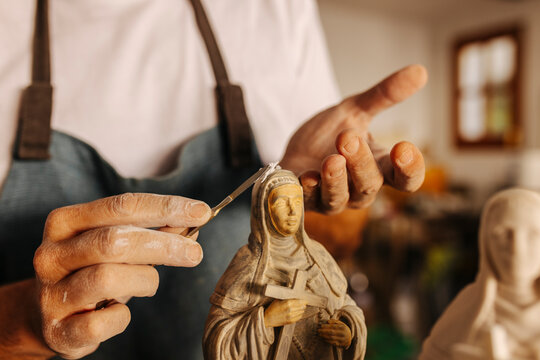 Crop artisan working with clay virgins in workshop