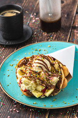 Hong kong or bubble waffle with ice cream, fruits, chocolate sauce and colorful candy