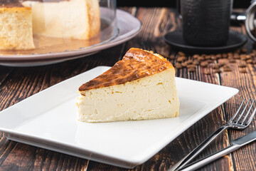 Sliced san sebastian cheesecake with coffee on wooden table