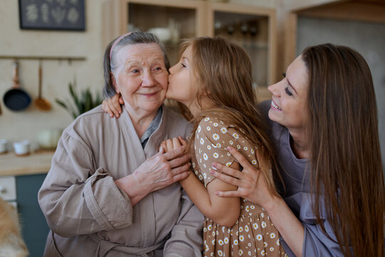 Portrait Of A Mother And Daughter Hugging A Grandmother