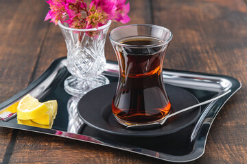 Top view of traditional black turkish tea with lemon and cookies on wooden background
