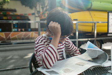 Teen reading periodical at street parklet