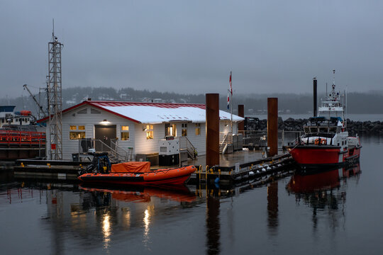Orange boat and floating building snowy winter dock in British Columbia