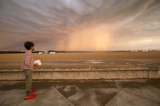 Boy looking lightning bolts at the beach