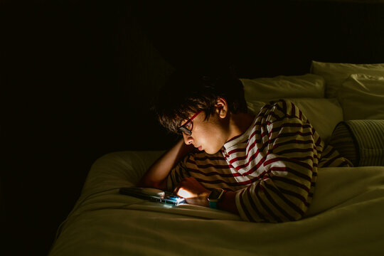 Boy with mobile phone in bedroom