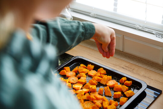 Woman adding condiment to cut pumpkin