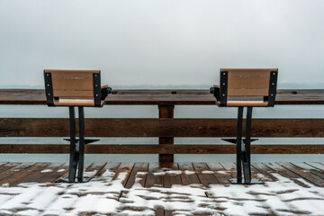 Two fishing seats on a snowy pier