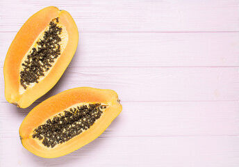 Papaya on pink wooden background, top view, copy space	