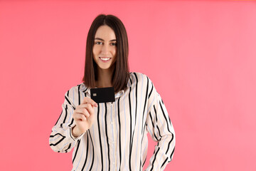 Attractive woman with card on pink background