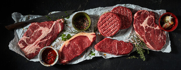 Raw meat steaks and patties with spices