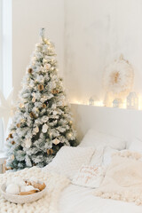 Light cozy bedroom decorated for celebrating Christmas. Eco style interior in white colors with...