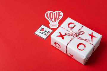 Valentine's Day concept with tic tac toe on gift box on red background