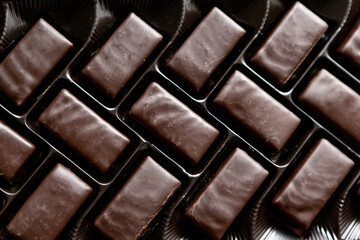 Chocolate candies in a row . Box with sweets