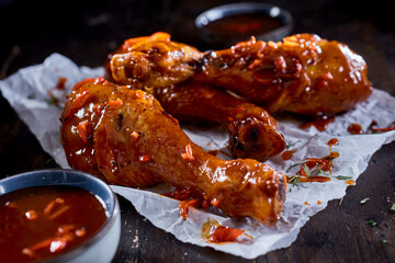 Tasty fried chicken drumsticks in chili sauce
