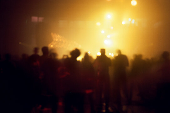 Anonymous people silhouettes dancing during a party