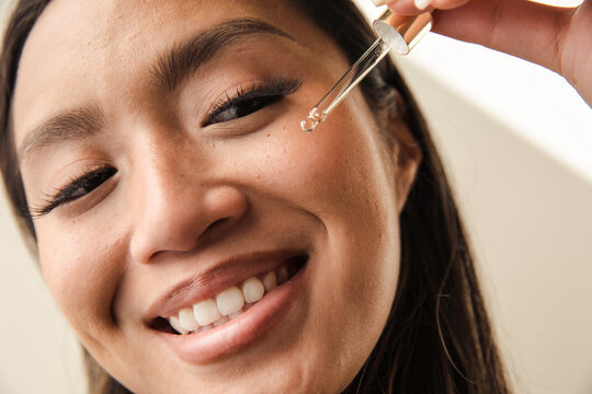 Happy model using face oil dropper