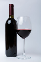 Glass of red wine and a bottle on colored table. Flat lay, top view wth copy space