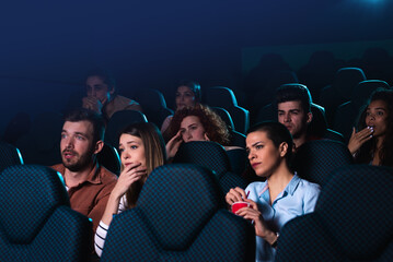 Group of people watching sad movie in cinema.