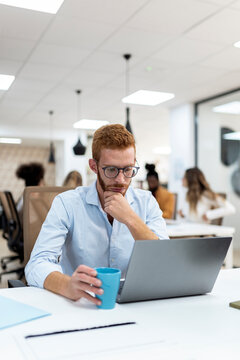 Portrait of a man using a laptop at an office