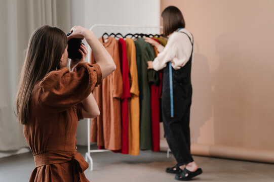 Woman taking photo of creative dressmaker