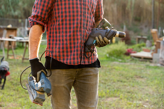Anonymous man holding tools outdoors