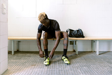 Black male footballer in changing room