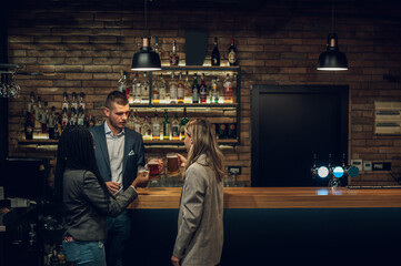 Cheerful colleagues drinking beer in the bar together after work