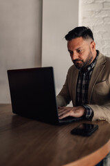 Businessman working on his laptop while drinking coffee in a cafe