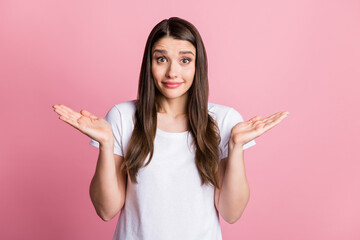 Portrait of attractive cheerful confused girl shrugging shoulders why isolated over pink pastel...