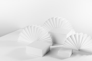 White abstract stage with set of three square white podiums mockup on table for showing, presentation cosmetic product, goods with oriental paper fans in minimal simple style, side view, corner, 3d.