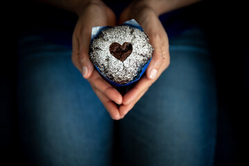 Hands of woman holding Valentines Day muffin