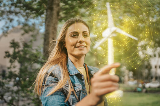 Woman holding glowing windmill model