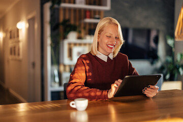 Delighted young caucasian woman, browsing the internet on her tablet.