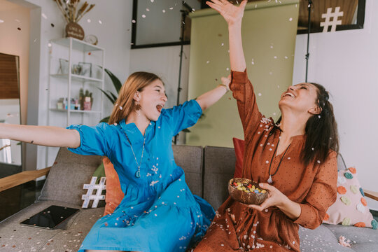 Women celebrating with confetti at home