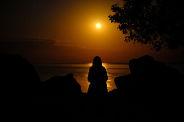 Person Watching Full Moon Over Lake 