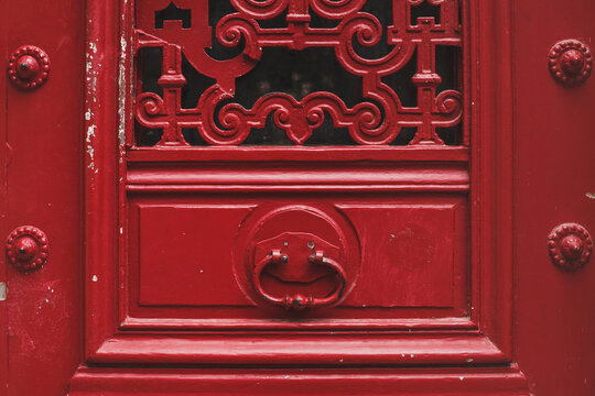 door painted in red with metal handle in Paris, France