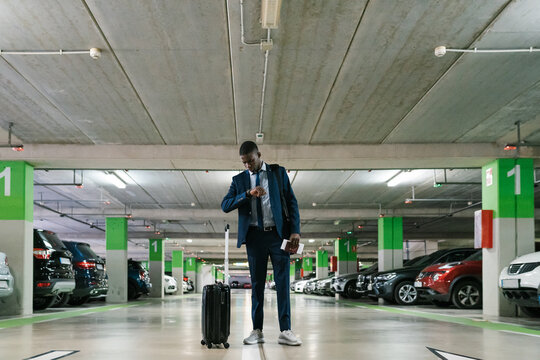 Businessman looking at time in airport car park
