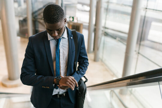 Stylish Executive Looking At The Clock On The Escalator