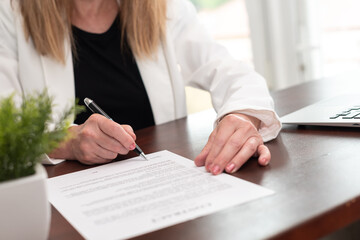 Hand of businesswoman signing a document  (Lorem ipsum text used)