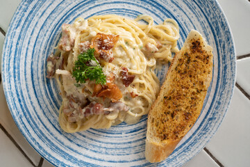 Carbonara pasta with pancetta, egg, hard parmesan cheese and cream sauce.