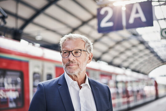 Businessman contemplating while standing at railroad station