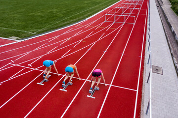 Germany, Baden Wurttemberg, Winterbach, Rear view of three female hurdlers right before start of race