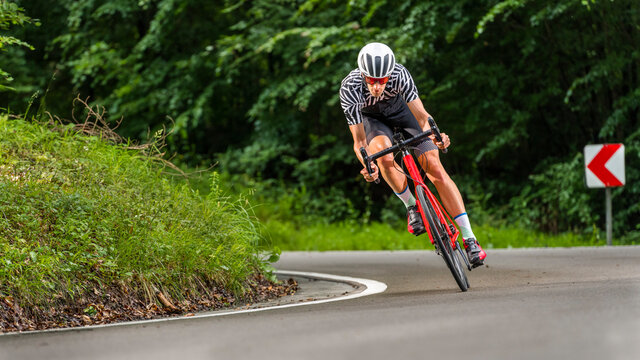 Male athlete exercising on racing bicycle in forest