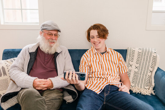 Grandchild and greybeard looking at phone