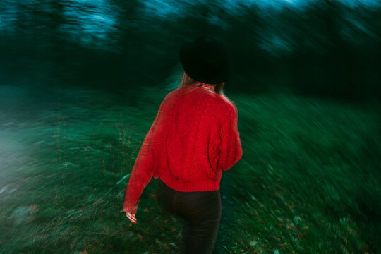 Anonymous woman walking at night. Long exposure