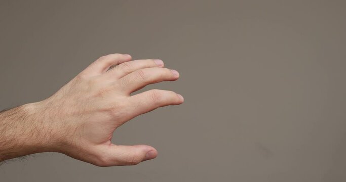 Caucasian male left hand slowly moving fingers randomly. Close up studio shot, isolated, real time, no people
