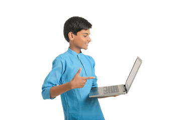 Technology concept : Cute indian little school boy using laptop