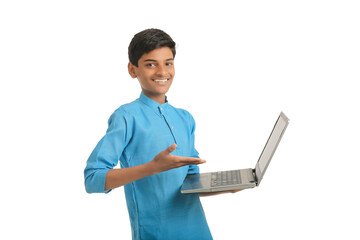 Technology concept : Cute indian little school boy using laptop
