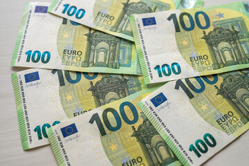 Fototapeta na wymiar beautiful new 100 euro banknotes laid out on a spacious table
